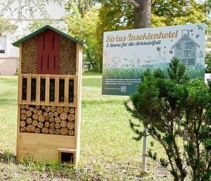 ESG-Maßnahmen für die Biodiversität: Ein Insektenhotel auf einer grünen Wiese an einem Standort von Sirius